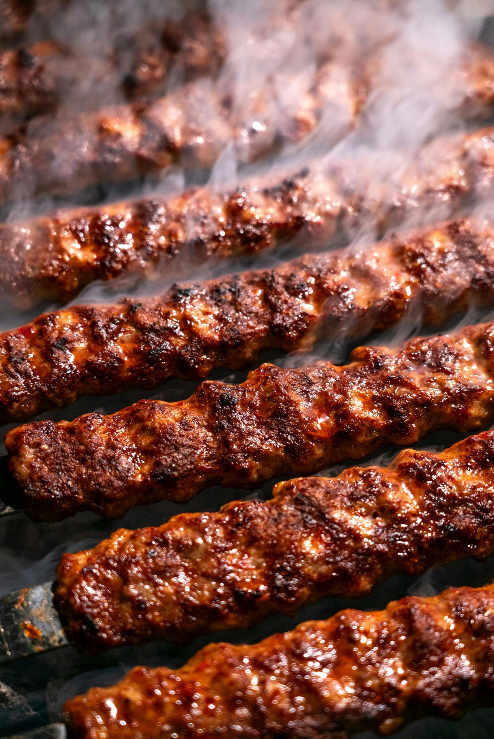 Шашлычный мир Close-up of delicious smoked kebabs grilling on a barbecue, capturing the rich, savory aroma and texture.